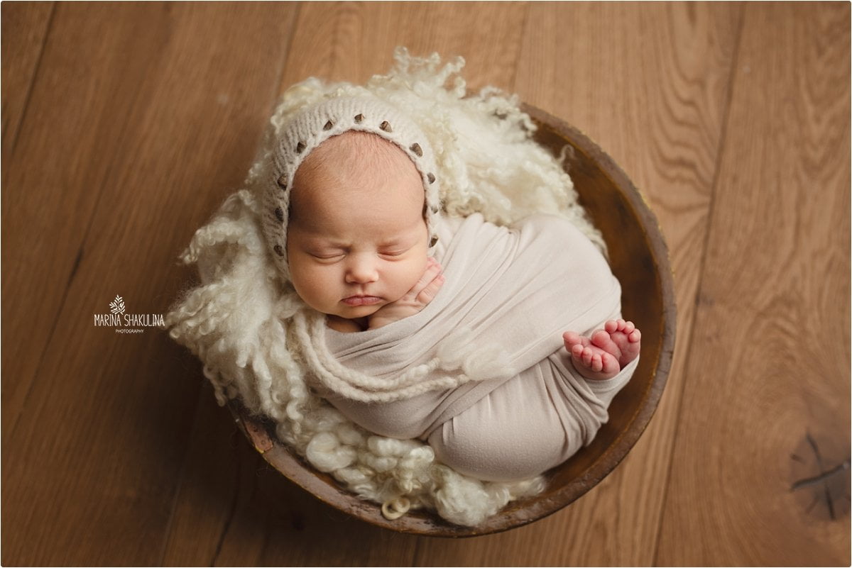 neonata in bianco su catino in legno