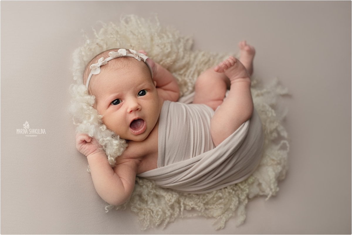 Neonata semi fasciata su tappetino di lana