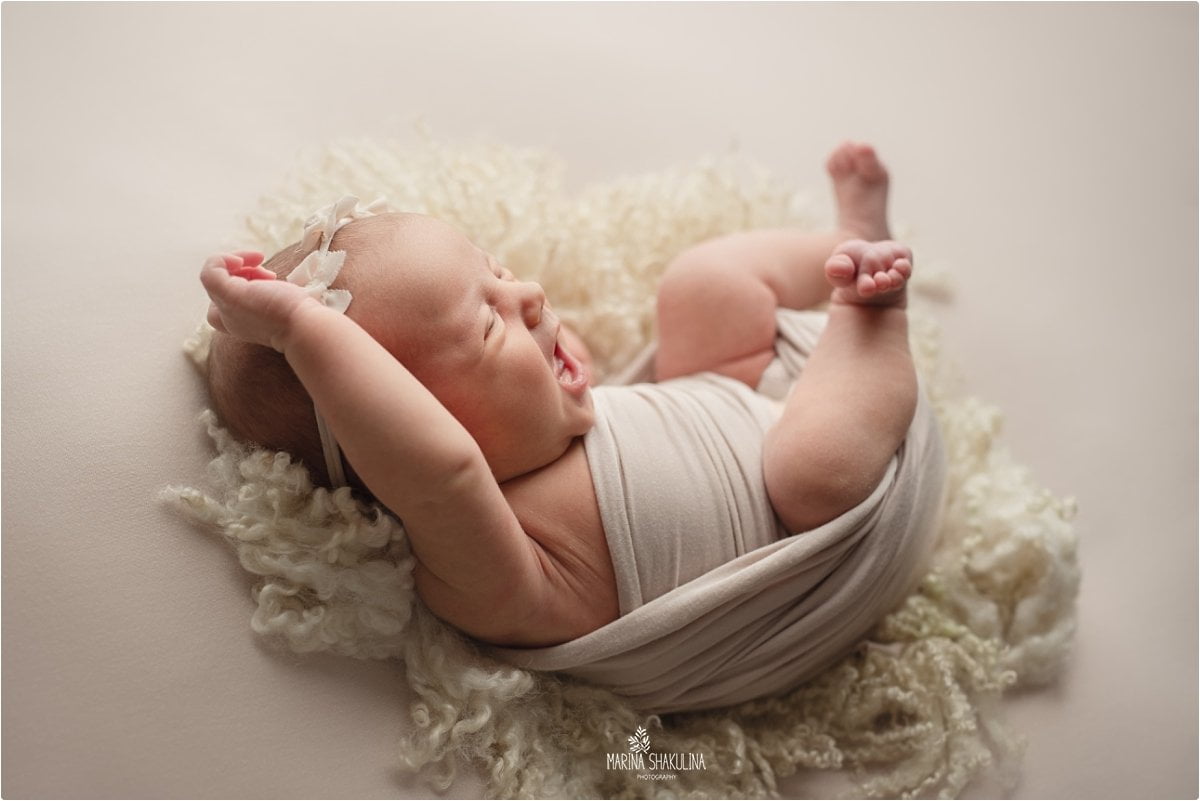 Neonata semi fasciata su tappetino di lana