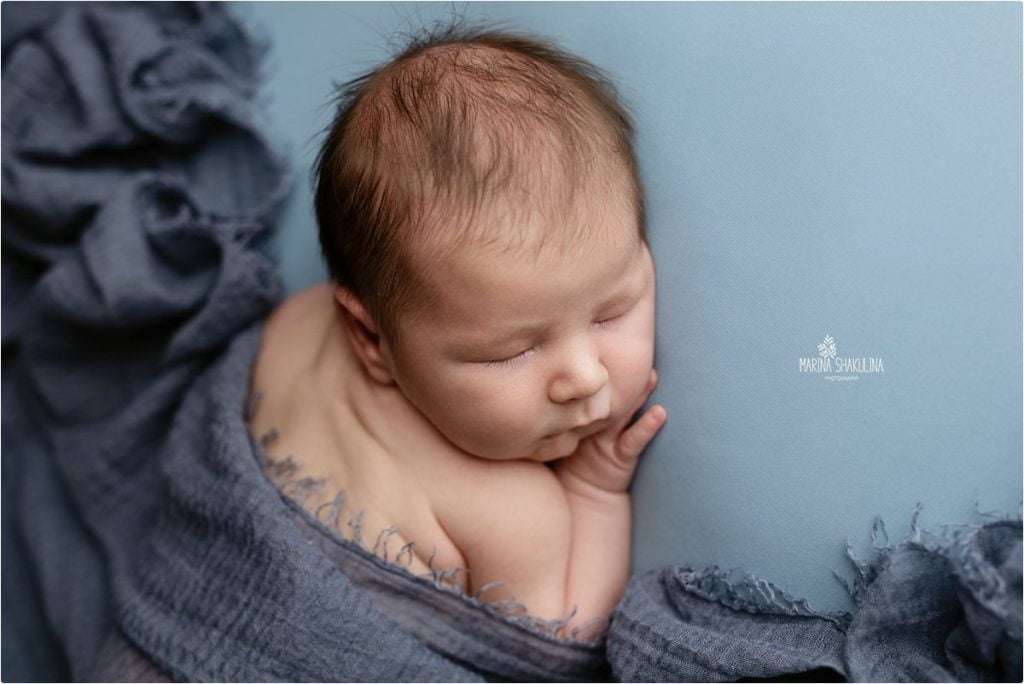 scatto neonato addormentato telo blu