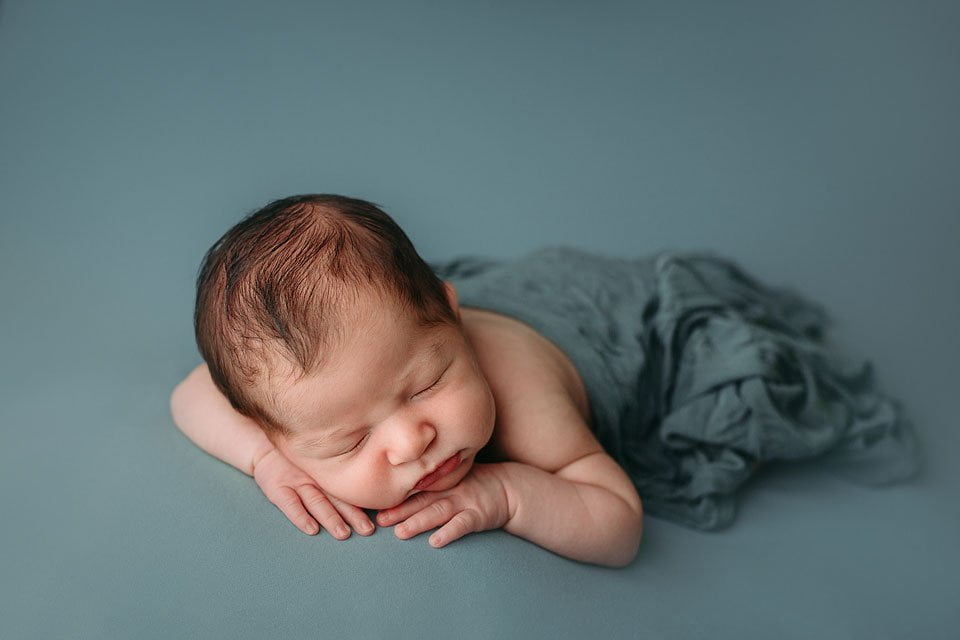 Servizio fotografico newborn - sdraiato fondo azzurro